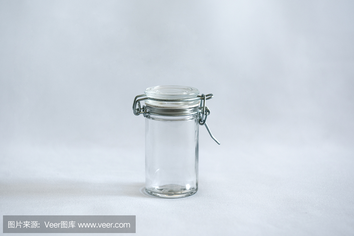 一个空的封闭玻璃罐,带有夹盖,背景为白色